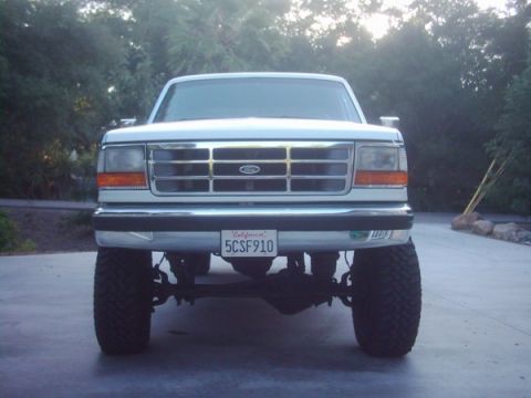 1978 Ford Bronco - This lifted Ford truck has a prominent grille and large off-road tires, seen from a straight-on front perspective.