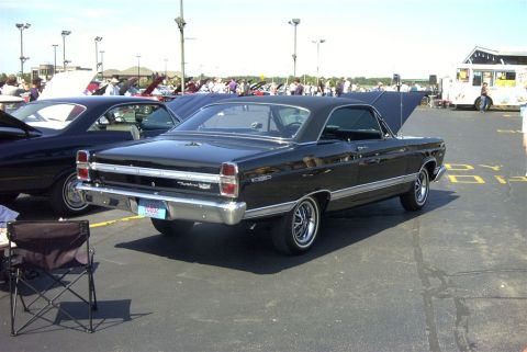 1967 Ford LTD - Black 1967 Ford Fairlane 500 coupe at a car show, hood open on another vehicle nearby.