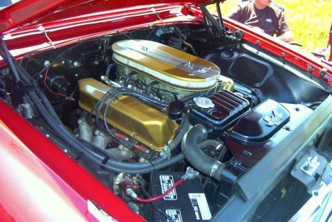 1967 Ford LTD - The engine bay of a red 1967 Ford LTD shows a V8 engine with gold accents and a prominent air filter.