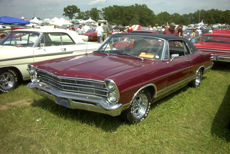 Maroon 1967 Ford convertible with black top, front 3/4 view at a car show.