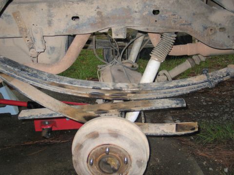 1995 Ford Bronco - Close-up view of a vehicle's rear suspension and brake assembly, with a red jack visible.