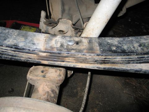 1995 Ford Bronco - Close-up view of the rear leaf spring suspension system, including a shock absorber and mounting hardware.
