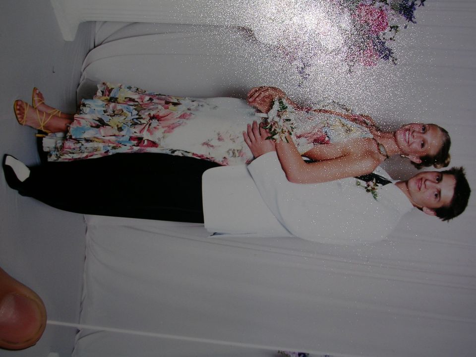 Couple in prom attire posing for a photo