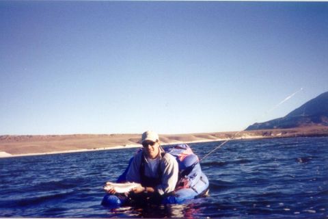 1996 Ford Bronco - A man enjoys a day of fishing from his raft on a calm lake.