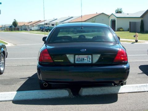 2001 Ford Crown Victoria - A dark 2001 Ford Crown Victoria is parked in a suburban neighborhood, showing its rear and Washington license plate.