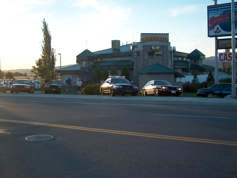 Police car and other vehicles parked in front of Home Plate building