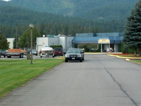 2001 Ford Crown Victoria - A police car is parked in front of a building with a boat trailer nearby.