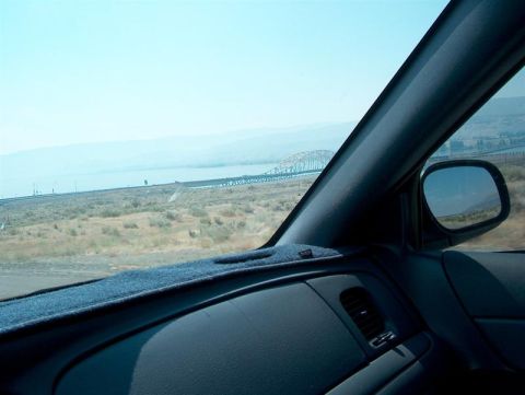 2001 Ford Crown Victoria - View from inside a vehicle looking out towards a bridge and a vast, dry landscape.