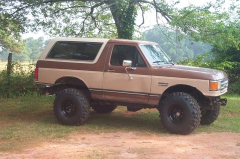 1987 Ford Bronco - This two-tone brown 1987 Ford Bronco features a body lift and aggressive off-road tires.