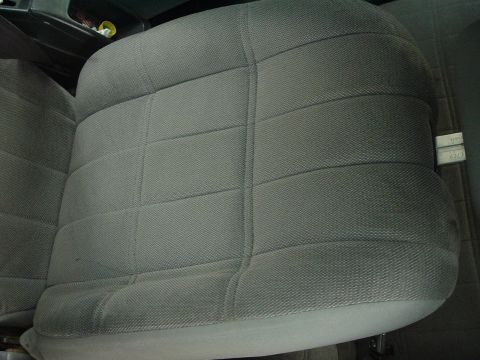 1989 Ford Escort - Interior view of a gray fabric car seat with visible stitching and a small label on the side.