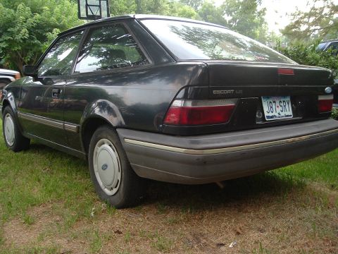 1989 Ford Escort - This 1989 Ford Escort hatchback is seen from the rear quarter angle, parked on a grassy area.
