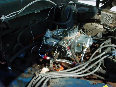 1973 Ford Ranchero - Close-up view of an engine bay a prominent carburetor and various hoses and wires.