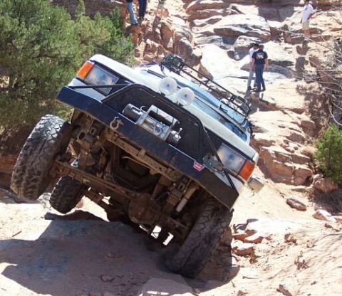1990 Ford Bronco - This 1990 Ford Bronco is navigating a challenging off-road obstacle on a rocky incline.