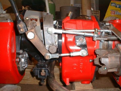 1990 Ford Bronco - Close-up of transfer case linkage with red and black components.