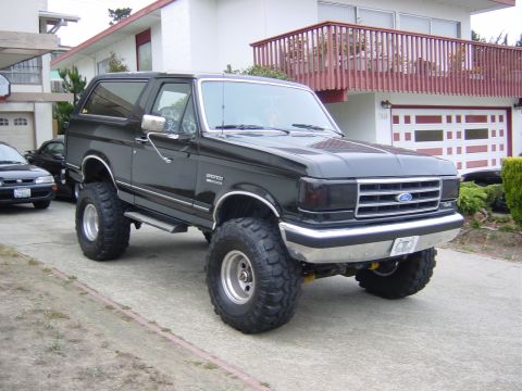 1990 Ford Bronco - This lifted 1990 Ford Bronco is parked in a driveway in front of a house.
