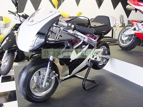 1998 Mercury Sable - A small sport bike style motorcycle is displayed indoors with other vehicles.