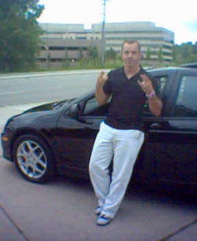 2004 Dodge SRT-4 - A man poses next to a black car, leaning against the driver's side door.