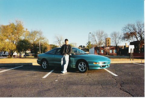 1993 Ford Probe - A man poses with his teal 1993 Ford Probe on a sunny day in a parking lot.
