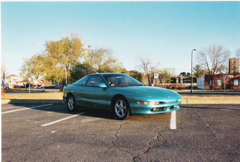 1993 Ford Probe - A teal 1993 Ford Probe is parked in an outdoor lot under a clear blue sky.