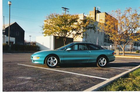 1993 Ford Probe - A teal 1993 Ford Probe is parked in a lot on a clear day.