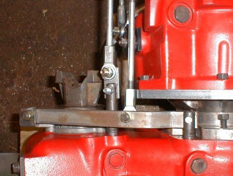 1990 Ford Bronco - Close-up view of a red transmission housing and associated linkage components.