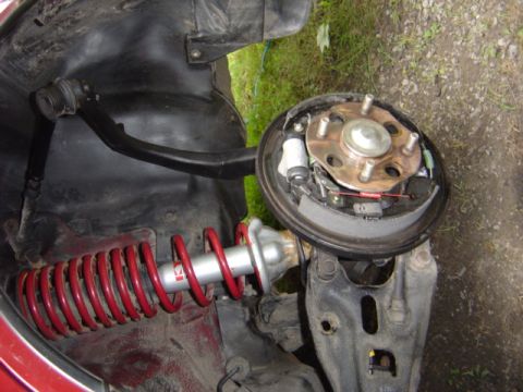 1998 Ford Taurus - The image shows a disassembled car suspension and brake system, focusing on the shock absorber and drum brake.