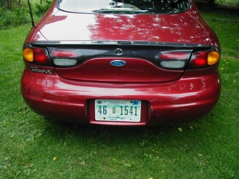 1997 Ford Taurus - Rear view of a red 1997 Ford Taurus sedan parked on grass.