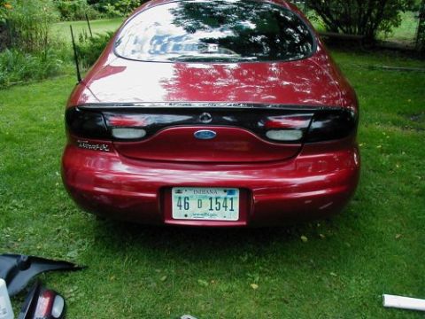 1997 Ford Taurus - Rear view of a red 1997 Ford Taurus parked on grass.