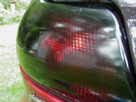 1997 Ford Taurus - Rear tail light assembly of a car, showing the red brake lights.