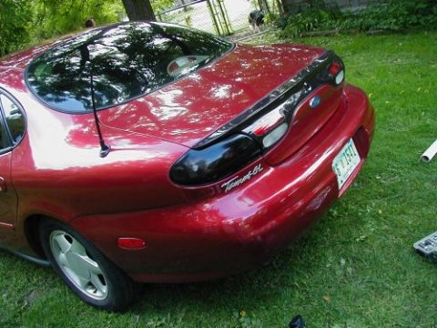 1997 Ford Taurus - The rear of a red 1997 Ford Taurus sedan is shown with custom blacked-out tail lights.