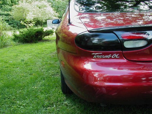 Red 1997 Ford Taurus GL rear quarter panel with modified black tail light