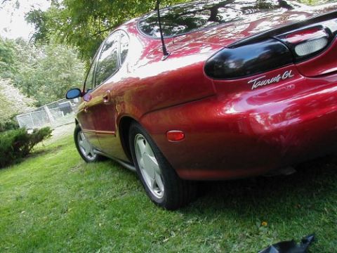 1997 Ford Taurus - Rear view of a red 1997 Ford Taurus GL parked on a grassy lawn.