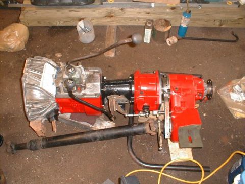 1990 Ford Bronco - A vehicle's transmission and transfer case assembly is shown on a workshop floor.