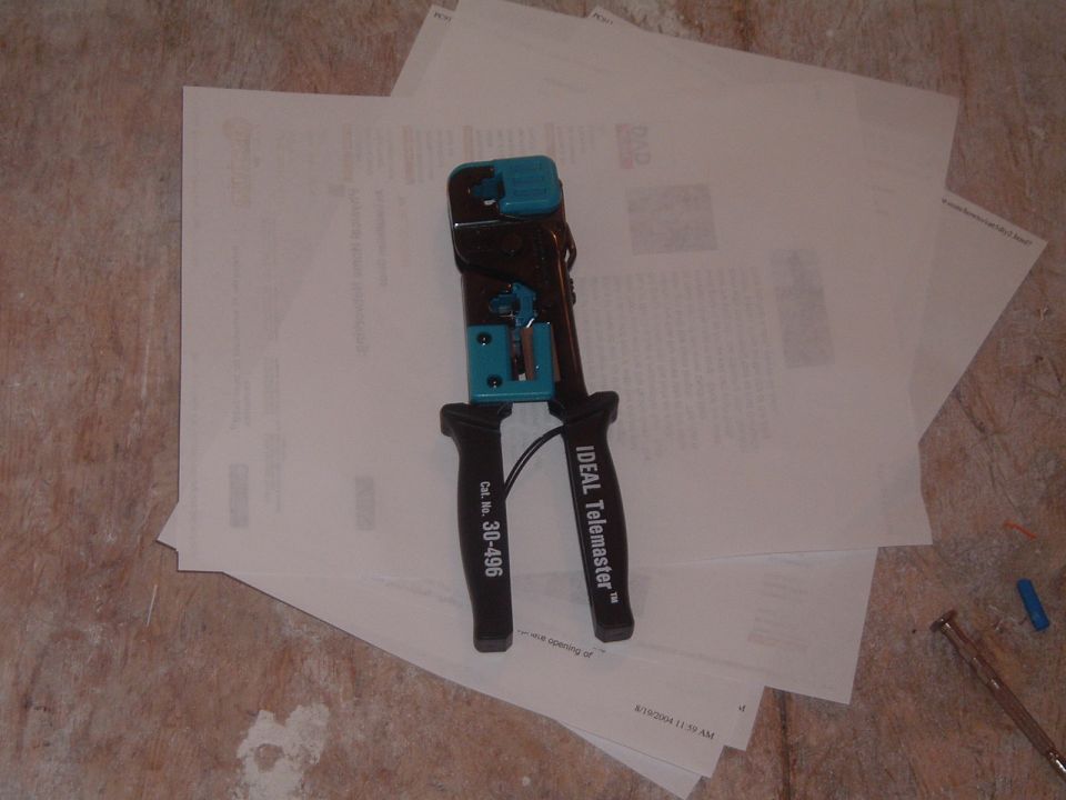 IDEAL Telemaster 30-496 modular crimp tool on printed pages on a plywood bench