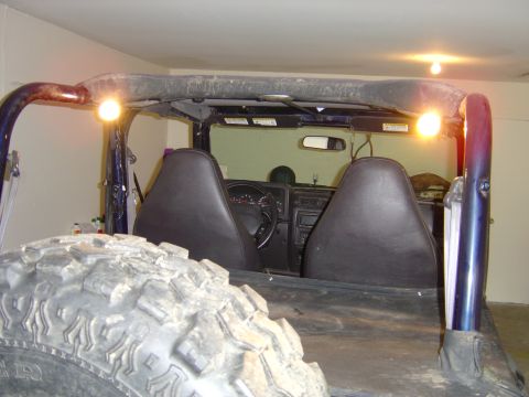 2002 Jeep Wrangler - The interior of a Jeep Wrangler is shown, with a spare tire in the foreground and the dashboard and seats visible.