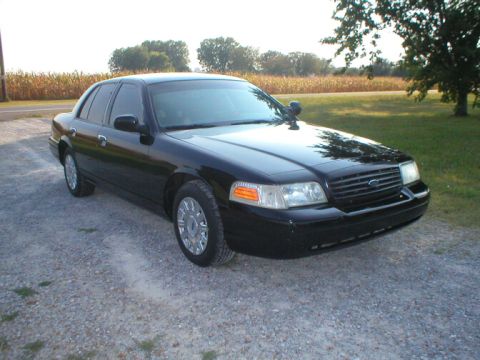 1987 Ford Crown Victoria LTD - This black Ford Crown Victoria is parked outside with a cornfield and trees behind it.