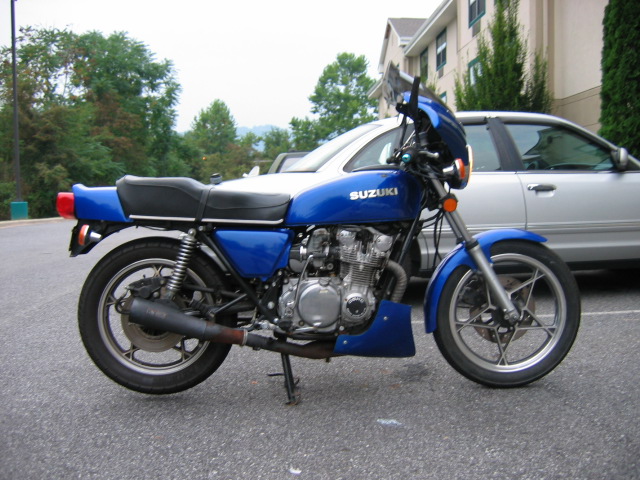 Blue Suzuki motorcycle parked next to a silver car