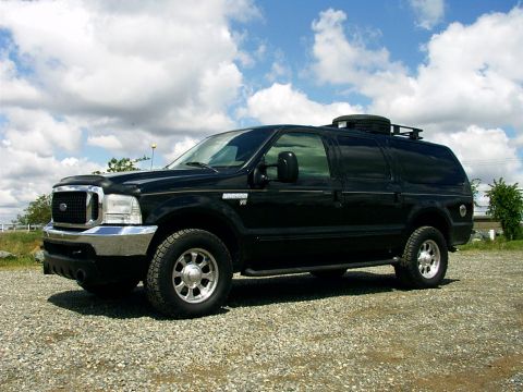2000 Ford Excursion - A black Ford Excursion is shown from the front-three-quarter view, parked outdoors on a gravel surface.