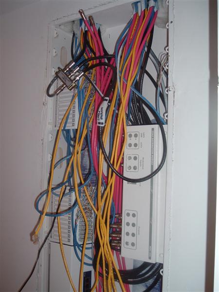 2000 Honda Accord - A complex network wiring panel is filled with a tangle of pink, yellow, blue, and black cables connected to various devices.