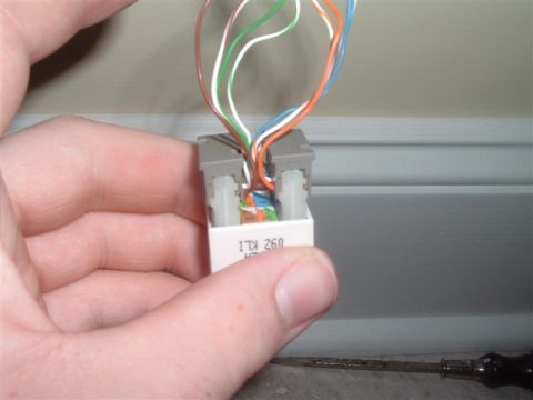 2000 Honda Accord - A close-up shows a hand holding a telephone wiring connector with several wires attached.
