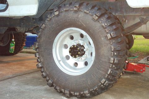 1995 Ford Bronco - Close-up of an Interco Super Swamper TSL Bogger mud tire mounted on a polished eight-hole aluminum wheel with an 8-lug hub, fitted to a whi…