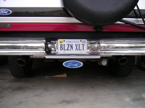 1994 Ford Bronco - Rear bumper close-up of a red and white Ford SUV with a chrome tube rear bumper, a Virginia vanity plate reading "BLZN XLT" with a Dec '04…