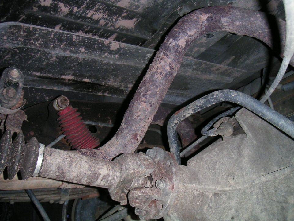 Underside view of driveshaft, U-joint and rear differential with red shock boot