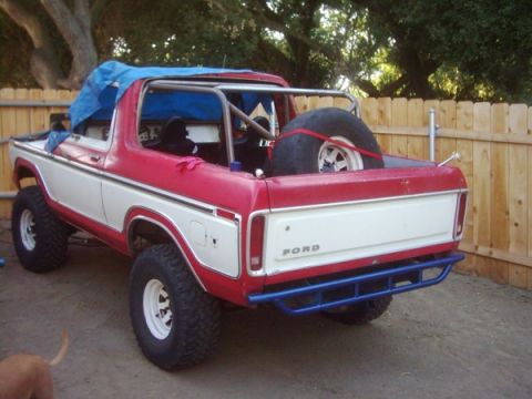 1978 Ford Bronco - This 1978 Ford Bronco is parked outside with a roll cage installed and a spare tire in the bed.