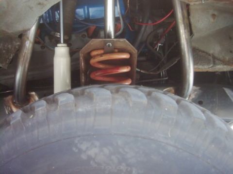 1978 Ford Bronco - This image shows a close-up view of a vehicle's suspension system and tire, with visible wiring and metal components.