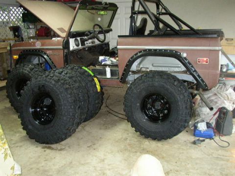 1995 Ford Bronco - This 1974 Ford Bronco is being modified with new tires and a roll cage inside a garage.