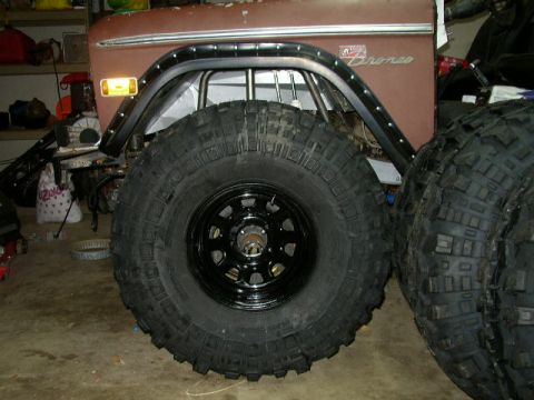 1995 Ford Bronco - Close-up of a Ford Bronco fender and a large off-road tire, with another tire to the side.