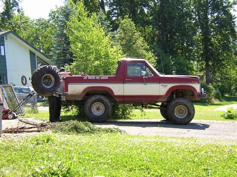1985 Ford Bronco - Ford Bronco lifted with spare tire mounted on the rear door, showing 'LAST FRONTIER 4X4 WHEELERS' text.