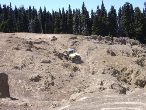 1991 Ford Bronco - Jeep Wrangler tackling challenging off-road terrain on a sunny day.