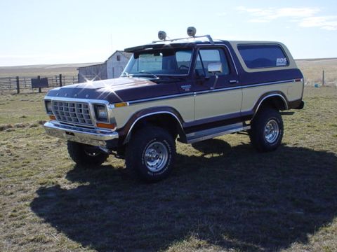 1979 Ford Bronco - A two-tone brown and tan Ford Bronco sits in a field with a barn in the background.